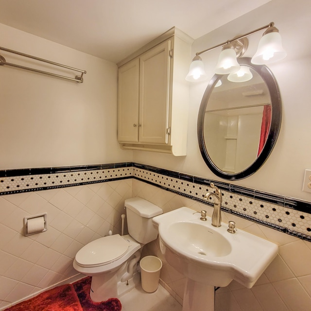 bathroom featuring toilet and tile walls