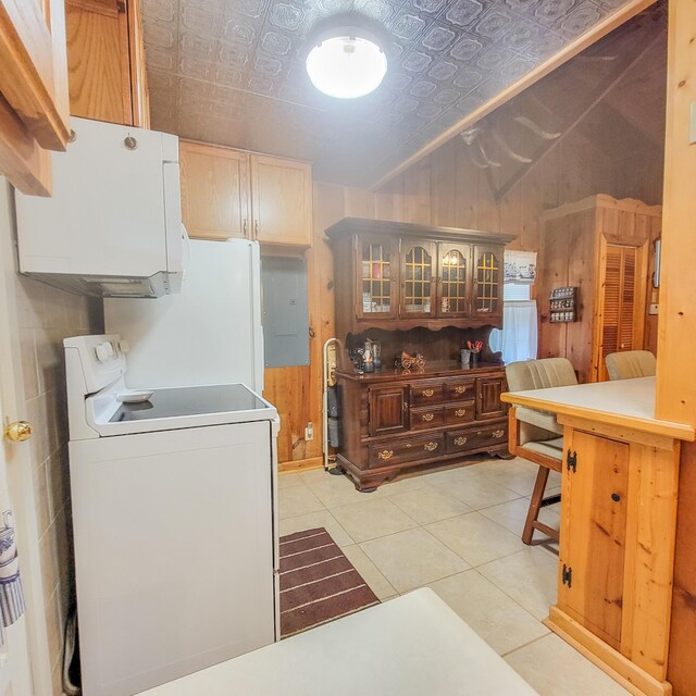 kitchen featuring wooden walls, light tile patterned flooring, an ornate ceiling, electric range oven, and glass insert cabinets