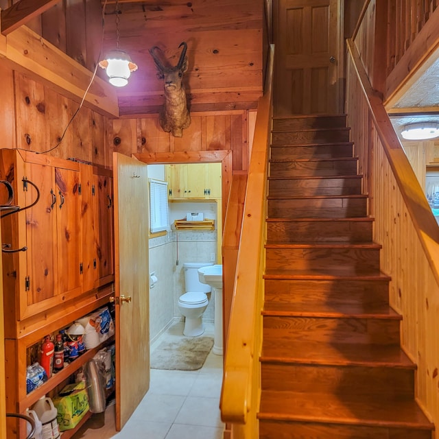 stairs with wooden walls and tile patterned flooring