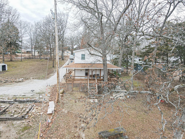 view of front of home with a deck and a shingled roof