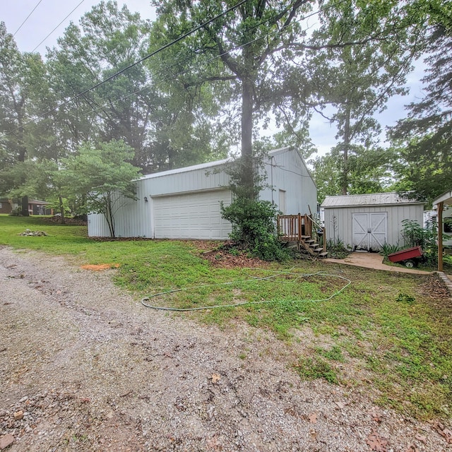 view of yard with an outbuilding, a detached garage, and a storage unit