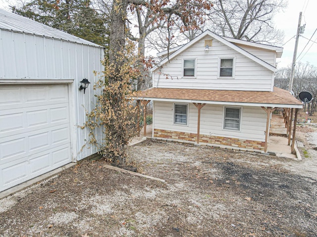 view of front facade with a garage and roof with shingles