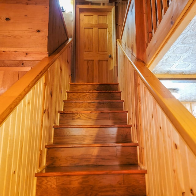 stairs featuring wooden walls