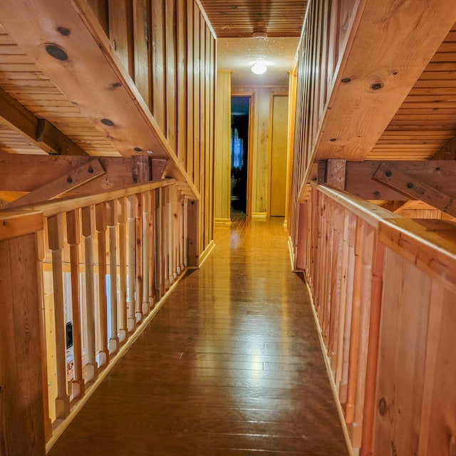 corridor featuring hardwood / wood-style flooring, wooden walls, and wood ceiling