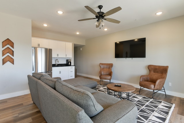 living room featuring hardwood / wood-style floors, sink, and ceiling fan