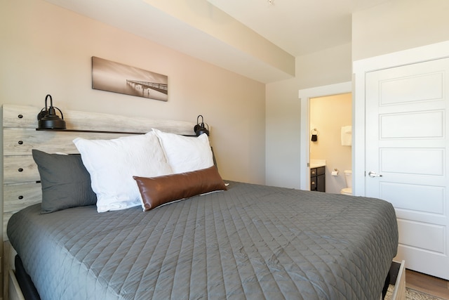 bedroom featuring ensuite bathroom and wood-type flooring