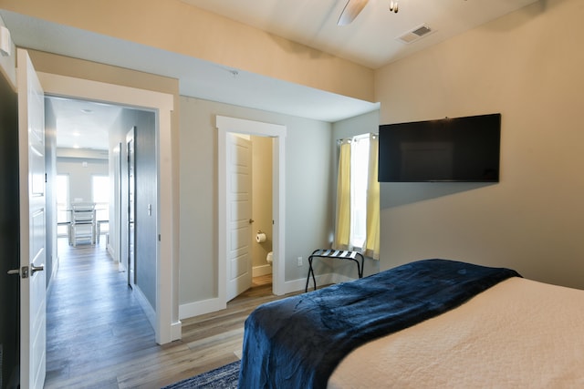 bedroom featuring ceiling fan, ensuite bath, and light hardwood / wood-style floors