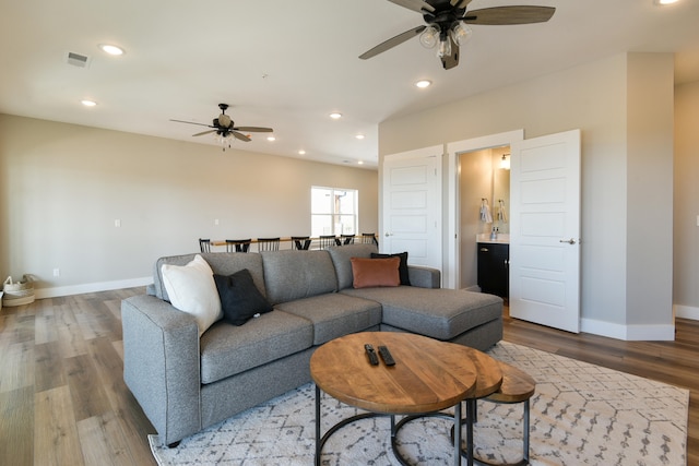 living room with light wood-type flooring and ceiling fan