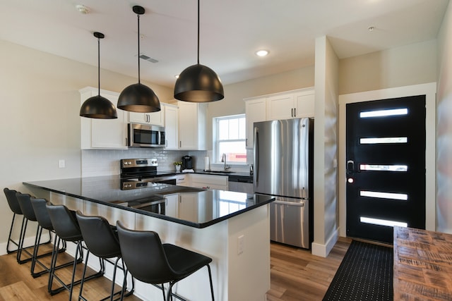 kitchen featuring white cabinets, appliances with stainless steel finishes, sink, and light hardwood / wood-style flooring