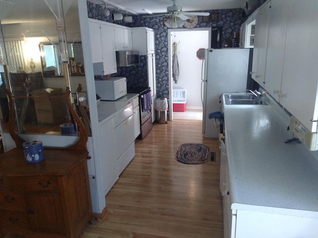 kitchen with ceiling fan, white cabinets, sink, stainless steel appliances, and light wood-type flooring