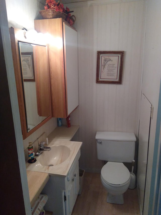 bathroom with vanity, toilet, and hardwood / wood-style flooring