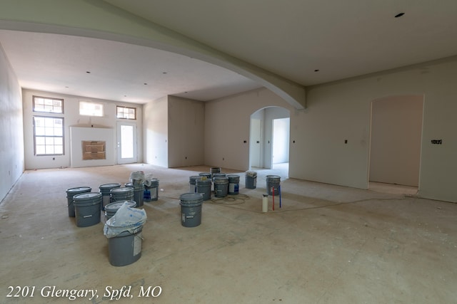 unfurnished living room featuring arched walkways