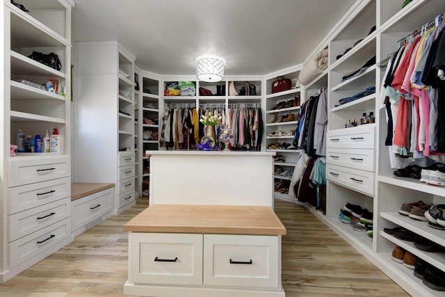 walk in closet with light hardwood / wood-style floors