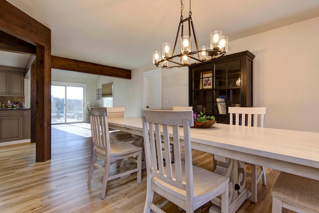 dining area with a notable chandelier and light hardwood / wood-style flooring