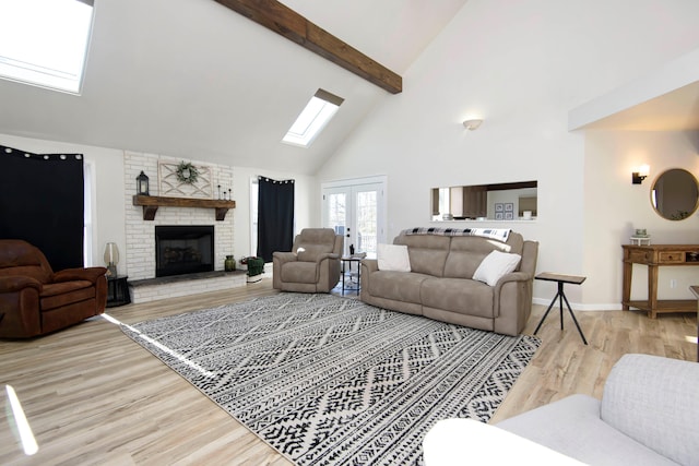 living room with a skylight, beam ceiling, high vaulted ceiling, a fireplace, and light wood-type flooring