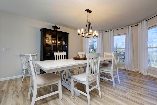 dining area featuring a chandelier, light hardwood / wood-style flooring, and a healthy amount of sunlight