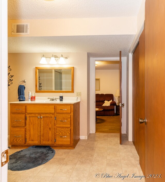 bathroom featuring tile patterned floors, vanity, and a textured ceiling