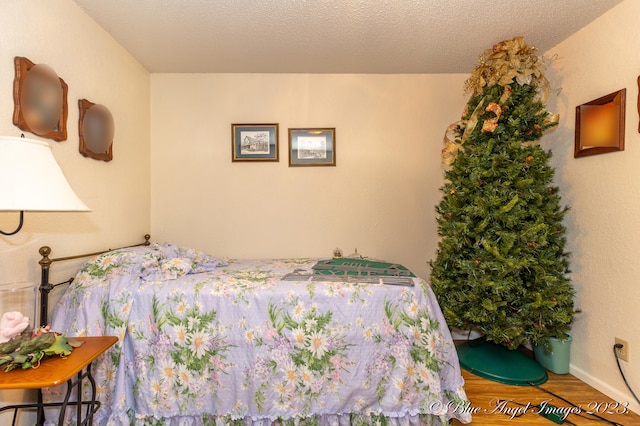 bedroom featuring wood-type flooring and a textured ceiling