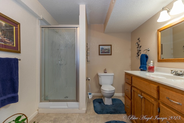 bathroom with vanity, a textured ceiling, a shower with shower door, tile patterned floors, and toilet