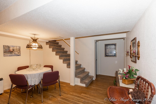 dining room featuring hardwood / wood-style flooring and a textured ceiling