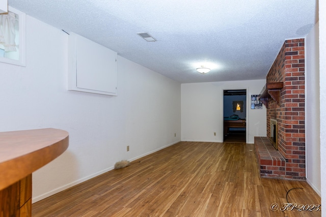4565 State Route Cc, West Plains, MO 65775 - interior space with a textured ceiling, light wood-type flooring, baseboards, a brick fireplace, and visible vents