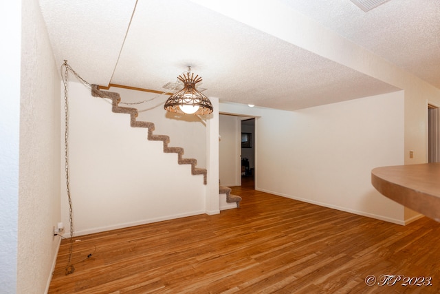 basement with wood-type flooring and a textured ceiling