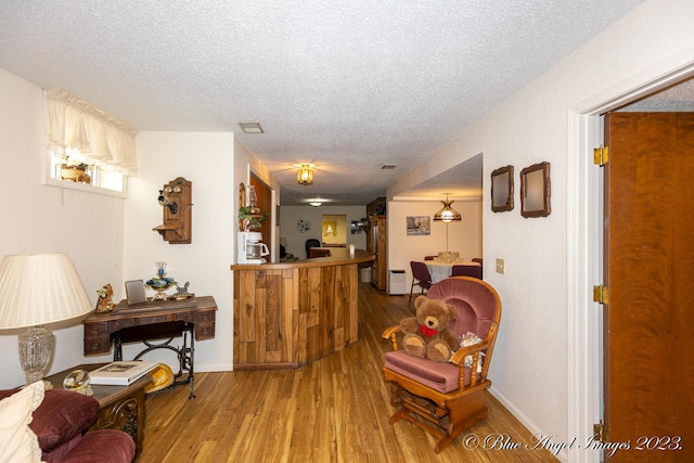 4565 State Route Cc, West Plains, MO 65775 - interior space featuring wood finished floors, a textured ceiling, bar area, baseboards, and visible vents