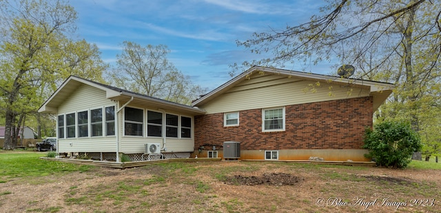 back of house featuring ac unit, a sunroom, and central AC