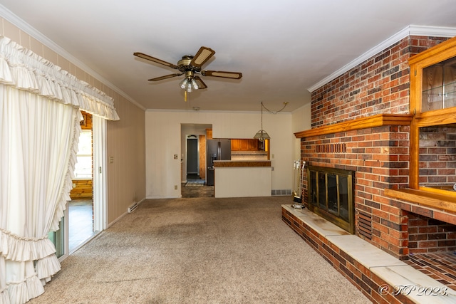 unfurnished living room with a fireplace, crown molding, and carpet