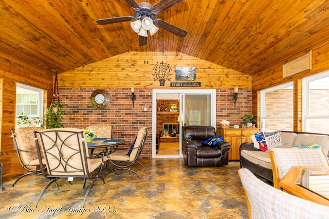 living room featuring ceiling fan, wood walls, wood ceiling, and brick wall