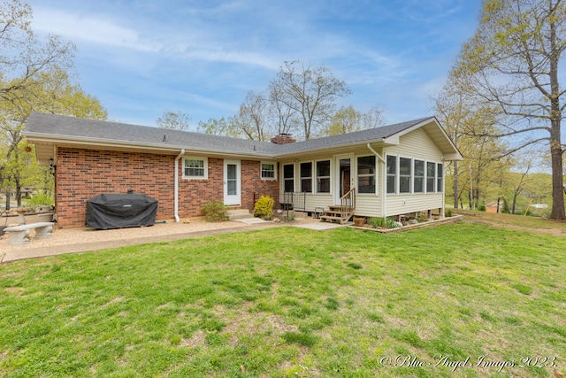 back of house with a sunroom, a lawn, and a patio