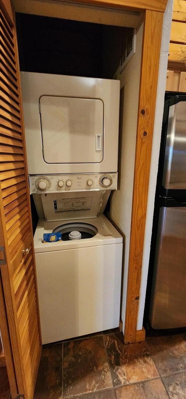 washroom with stacked washing maching and dryer