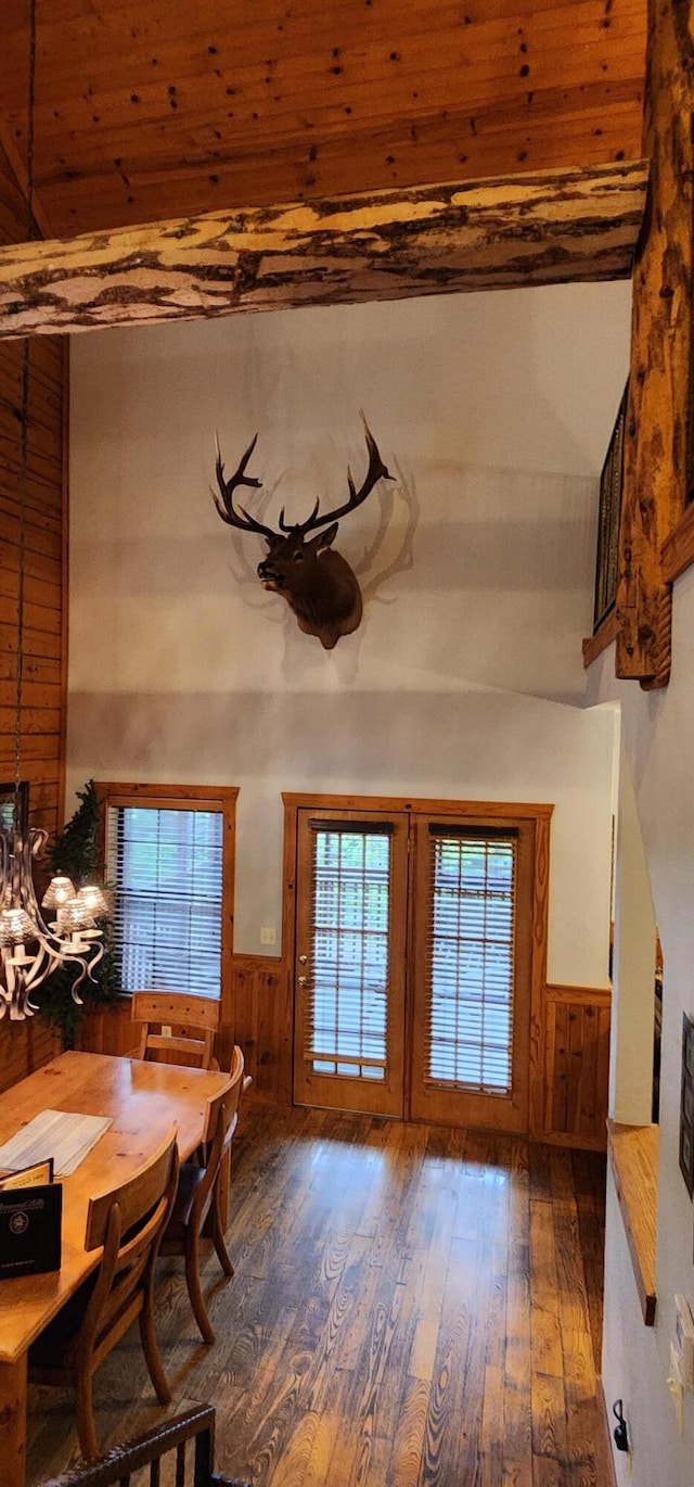 dining room featuring wooden walls, dark wood-type flooring, wooden ceiling, and french doors