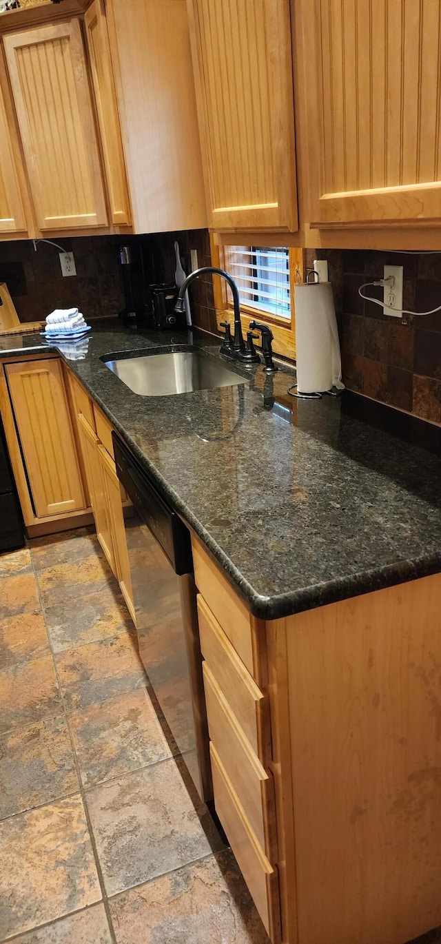 kitchen featuring decorative backsplash, dark stone counters, dishwasher, and sink