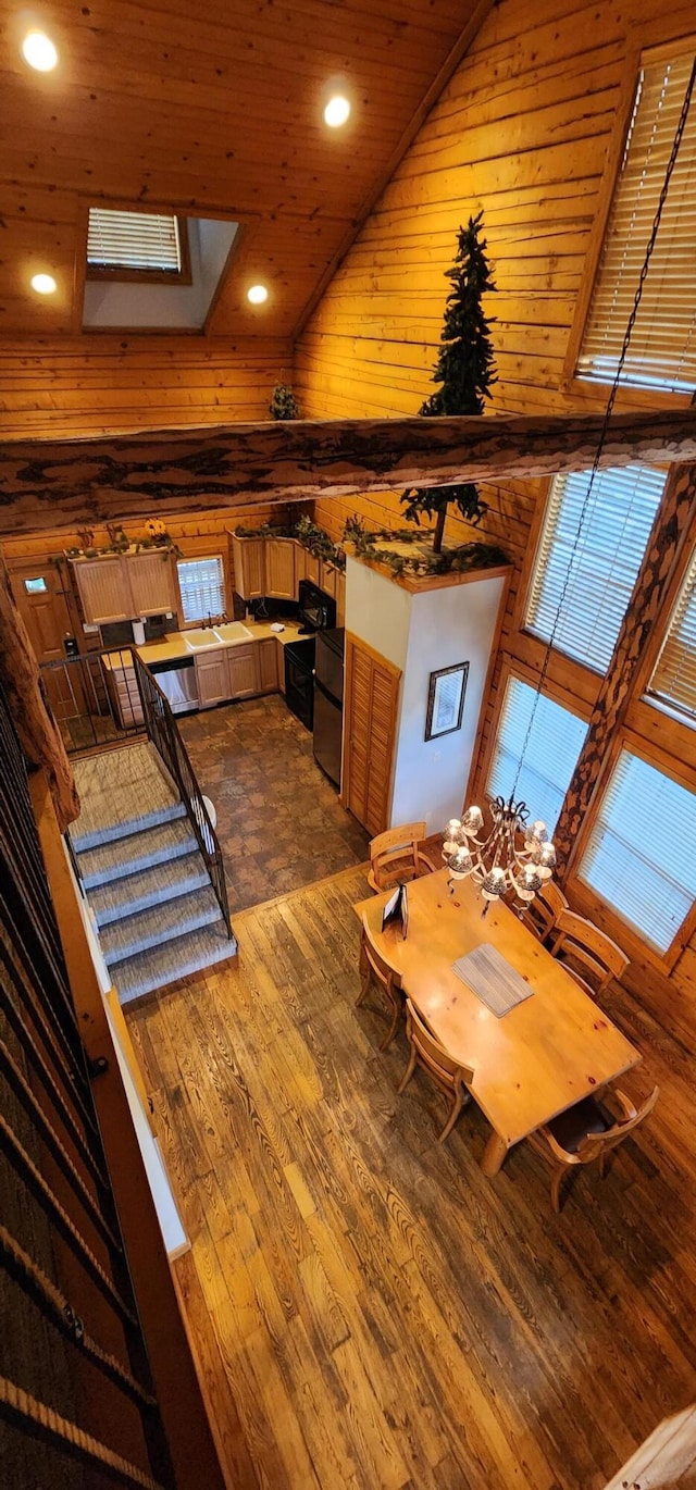 unfurnished dining area featuring wood walls, wood-type flooring, high vaulted ceiling, and wooden ceiling