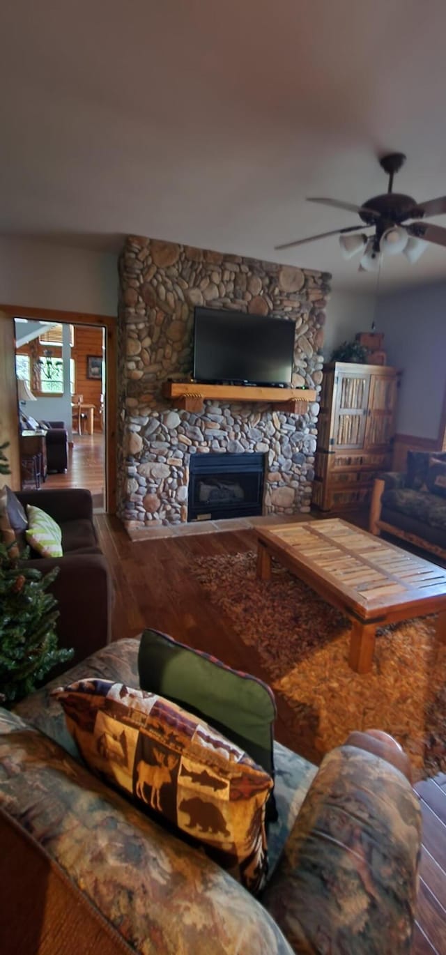 living room with a fireplace, ceiling fan, and hardwood / wood-style floors