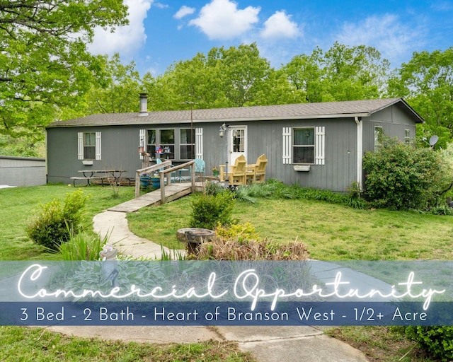 view of front of house with a wooden deck and a front lawn