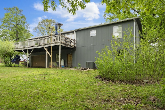 rear view of property with a yard, a deck, and central AC unit