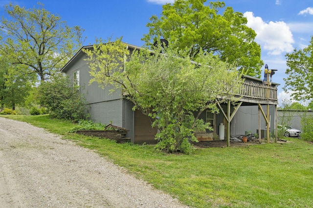 rear view of house featuring a lawn and a deck