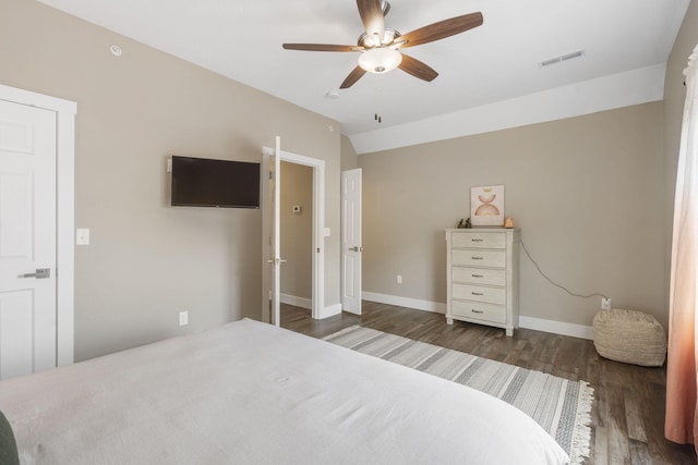 bedroom featuring lofted ceiling, visible vents, a ceiling fan, baseboards, and dark wood-style flooring