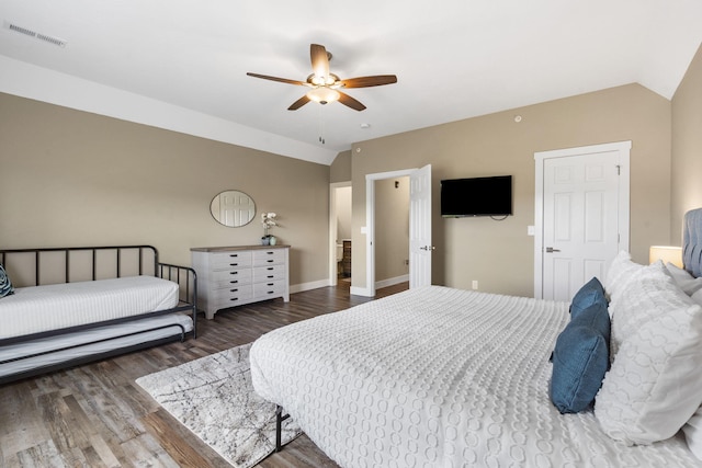 bedroom featuring lofted ceiling, wood finished floors, visible vents, baseboards, and ceiling fan