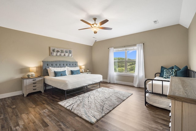 bedroom with ceiling fan, vaulted ceiling, and dark hardwood / wood-style flooring