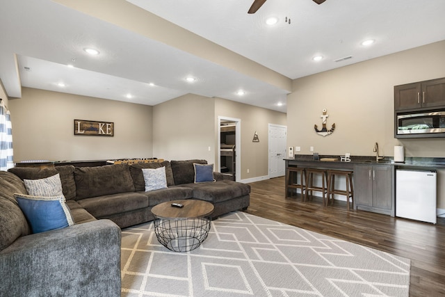living room with a ceiling fan, dark wood finished floors, baseboards, visible vents, and recessed lighting