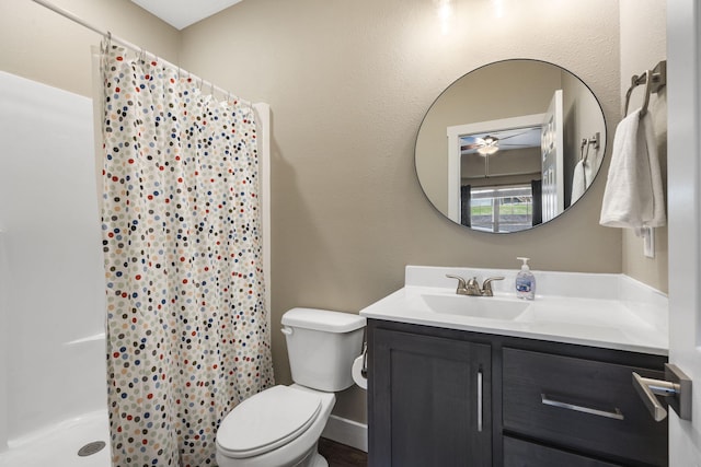 bathroom with ceiling fan, vanity, toilet, and curtained shower