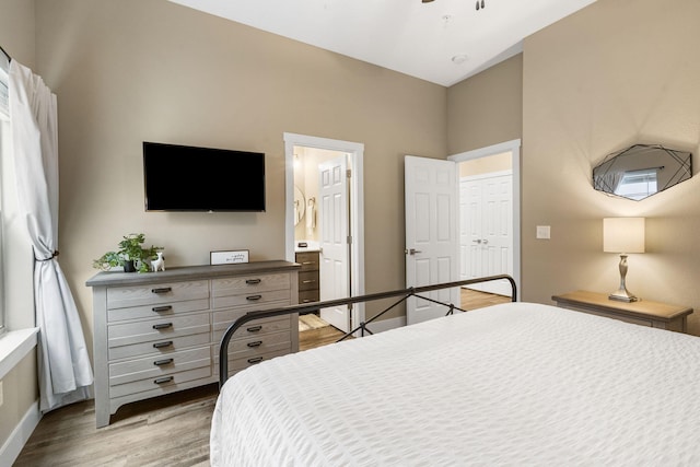 bedroom featuring ensuite bathroom, a closet, and light hardwood / wood-style floors