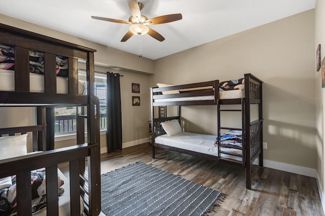 bedroom featuring wood finished floors, baseboards, and ceiling fan