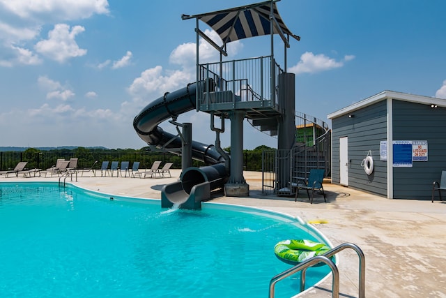 view of swimming pool featuring a water slide and a patio