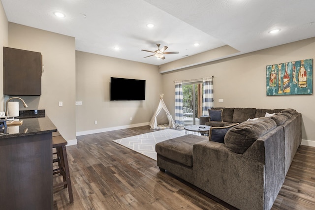 living room with ceiling fan, dark hardwood / wood-style flooring, a textured ceiling, and sink