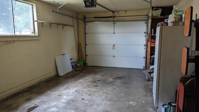 garage with white refrigerator and a garage door opener