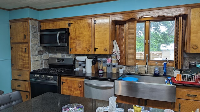 1404 6th St, Monett, MO 65708 - kitchen with stainless steel appliances, brown cabinets, backsplash, and dark countertops
